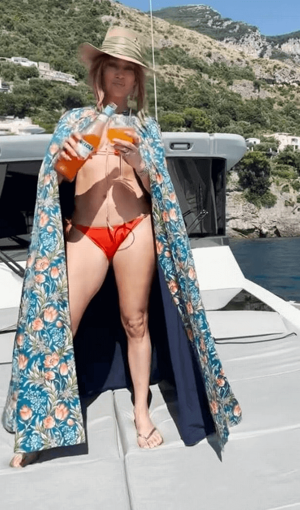 A tiny red bikini and colorful cover-up covered the singer's tiny body on the deck of a yacht off the coast of Italy.
